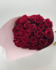 A bouquet of 24 premium red roses with long stems, elegantly wrapped.