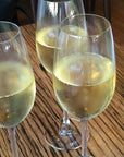 Three wine glasses filled with sparkling wine on a wooden table