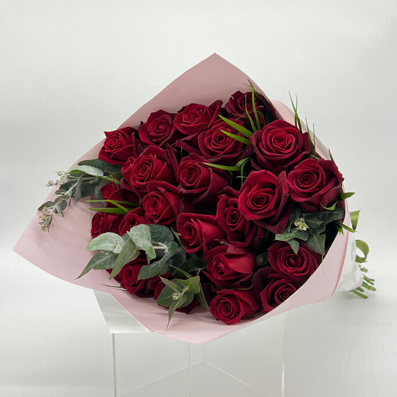 A bouquet of 24 premium red roses with foliage, elegantly wrapped.
