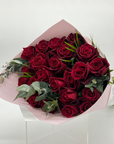 A bouquet of 24 premium red roses with foliage, elegantly wrapped.