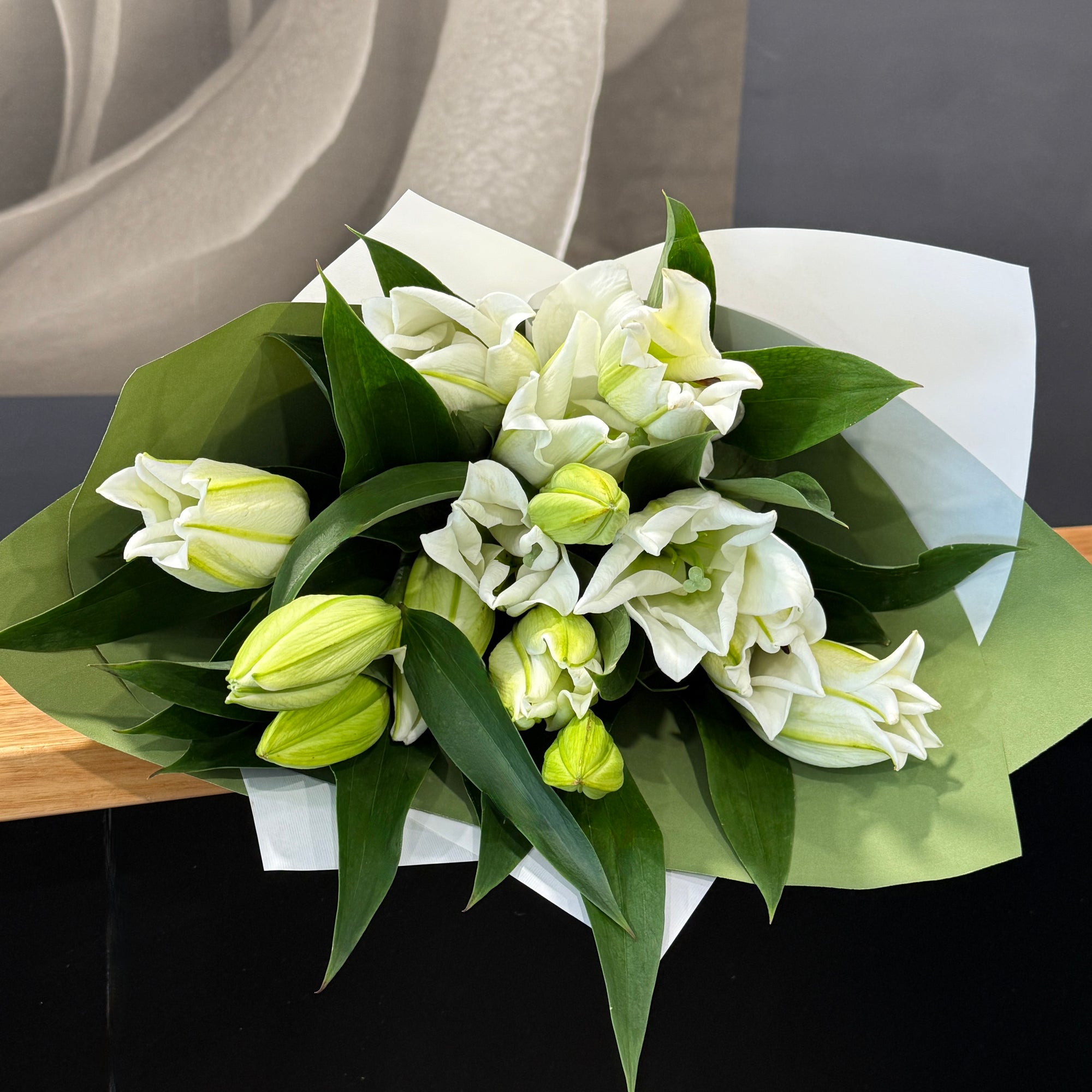 Bouquet of white Oriental Lillies and foliage, gift wrapped.