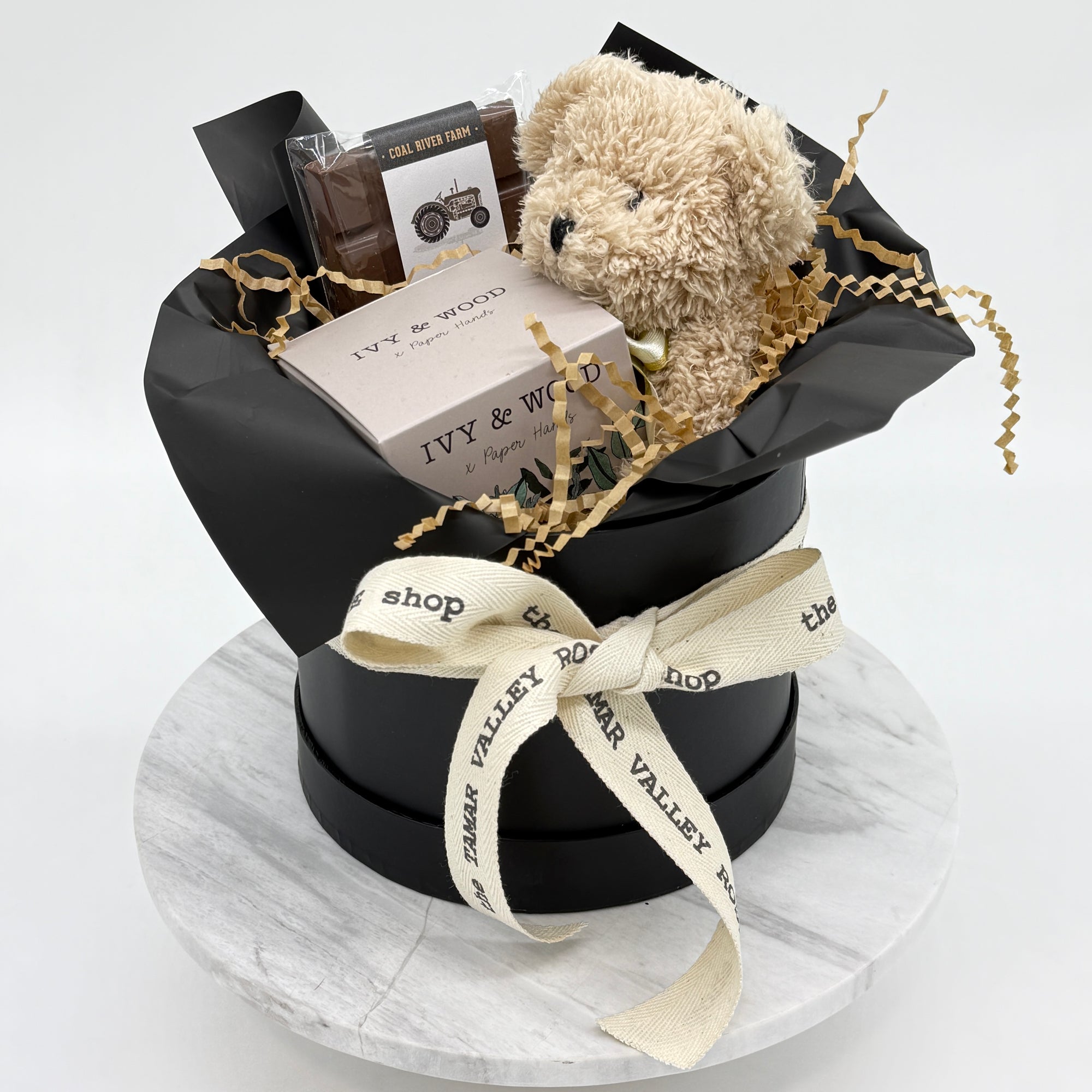 Hat Box with teddy bear, Candle and Chocolate bar on a white background