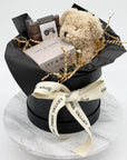 Hat Box with teddy bear, Candle and Chocolate bar on a white background