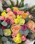 Bouquet of colorful roses with eucalyptus leaves on a white background